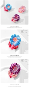 Detailed macro view of colorful jelly-textured acetate flower hair claws in pastel colors