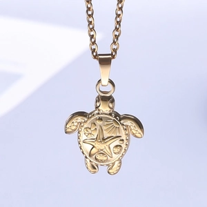 Macro view of gold sea turtle pendant with embossed starfish and scallop shell textures