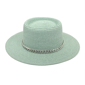 Detail of light green straw hat with wide brim and decorative silver metal chain link