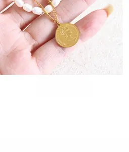 Detail of gold Elizabeth II coin pendant necklace with half pearl and metal chain
