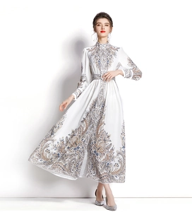 Close-up of elegant blue paisley print on white long-sleeve maxi dress with waist belt