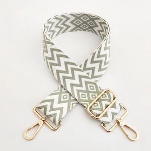 Detail of adjustable 5cm wide woven bag strap with green and beige geometric patterns