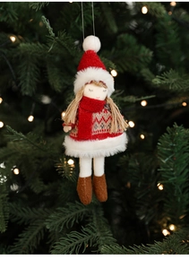 Detail of plush Christmas girl ornament with red hat and white faux fur skirt on tree