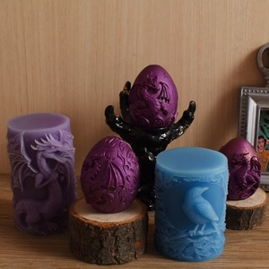 Detailed relief dragon eggs and cylindrical silicone molds on a natural wood surface