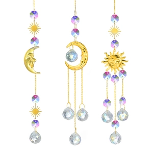 Three gold sun and moon crystal suncatchers with faceted glass prisms on white background