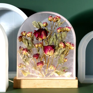 Macro view of dried rose flowers preserved in arched resin with an illuminated wood base
