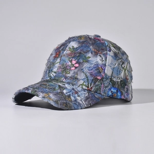 Detail of distressed denim baseball cap featuring vintage floral patterns and frayed edges