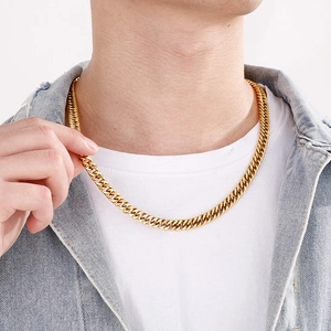 Close-up of gold titanium steel Cuban link chain necklace worn on a male model neck