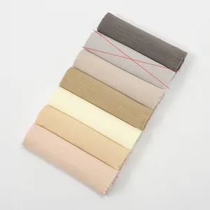 Close-up of slub cotton scarves in gradient neutral tones with fringe detail