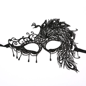 Detail of black lace masquerade mask with peacock feather pattern and beaded tassels