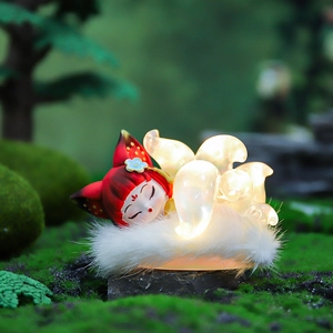 Sleeping red nine-tailed fox resin night light on white plush base with warm LED glow