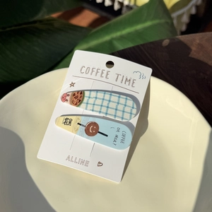 Detail of coffee theme hair clips with blue plaid patterns on beige plate