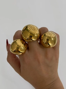 Detailed view of three chunky 18K gold-plated spherical rings with high-polish metallic finish