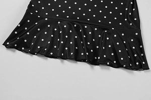 Detailed view of polka dot dress featuring a ruffled hem and fine stitching details