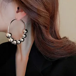 Boucles d'oreilles créoles en argent avec perles coulissantes portées par un mannequin