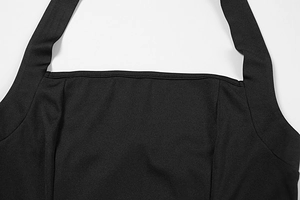 Dettaglio dello scollo e delle spalline halter di un abito nero con cuciture precise