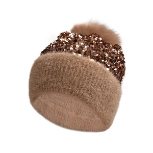 Detail of winter knit beanie with metallic sequins and large brown faux fur pom-pom