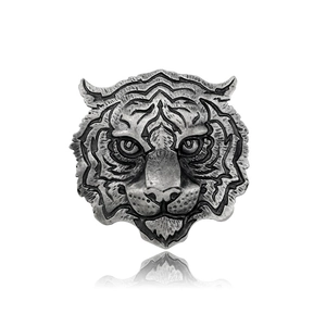 Detailed macro shot of an antique silver tiger head brooch with intricate metal texture