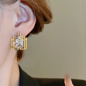Close-up of luxury gold square zircon stud earring with vintage metal window frame design
