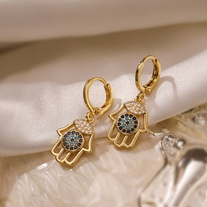 18K gold plated Hamsa Hand earrings with blue and white zircons on white silk