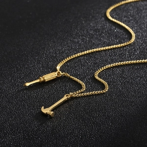 Detail of creative gold hammer and screwdriver pendants on a metallic tool necklace