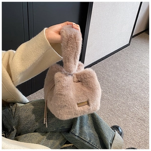 Detailed view of light brown faux fur bucket bag with drawstring and plush handle
