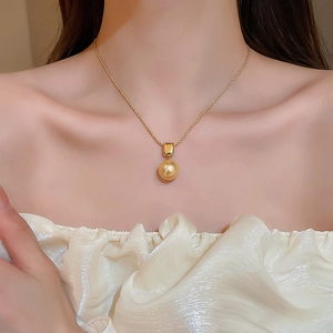 Gros plan d'un élégant collier en maille corde plaqué or 18 carats avec perle de champagne