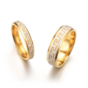 Close-up of stainless steel couple rings with vintage Greek key meander pattern