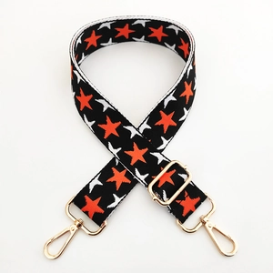Adjustable wide knitted bag strap with orange star patterns and gold metal swivel clips