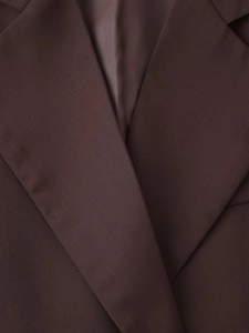 Detail of lapel collar and fine twill fabric texture on a dark brown slim fit blazer