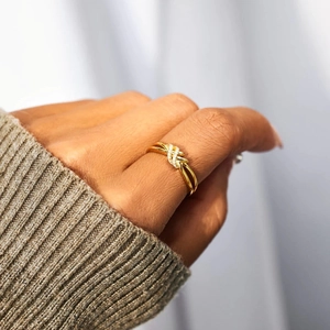 Bague nœud en argent S925 doré poli avec zircons portée sur la main d'un mannequin