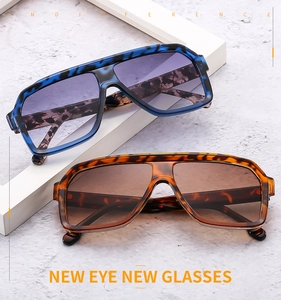 Detail of oversized aviator sunglasses with leopard frames and gradient lenses on a pedestal