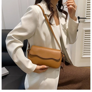 Brown leather crossbody bag styled with a white blazer for a chic minimalist fashion look