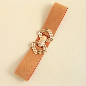 Détail d'une boucle en métal doré sur une ceinture élastique orange texturée