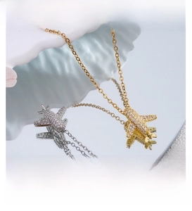 Detailed macro view of airplane pendant set with shimmering zircons on a reflective surface