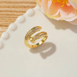 Detailed close-up of a gold nail-shaped wrap ring with sparkling cubic zirconia inlay