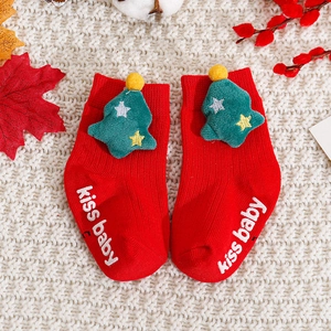 Detail of red Christmas baby socks with 3D tree decor and anti-slip kiss baby grip