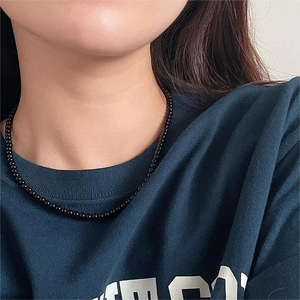 Detail of a 3-4mm black onyx bead choker necklace worn on a model's neck for elegant style