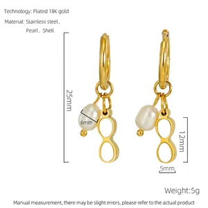 Detailed view of 18K gold plated stainless steel earrings with pearl and shell charms