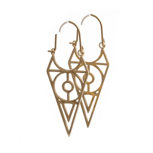 Macro shot of gold geometric triangle earrings with evil eye motif on a clean white background