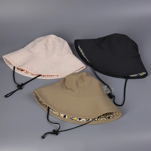 Detail of water-resistant nylon bucket hats in beige, black, and khaki with printed lining
