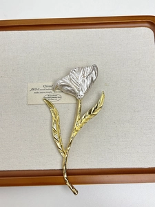 Detailed view of bicolor tulip brooch with silver textured petals and golden metallic stem