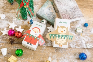 Exquisite Christmas sock gift box with Santa and owl motifs on a festive snowy wooden table