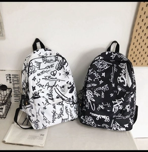 Detail of street graffiti style canvas backpacks in black and white side by side
