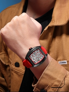 Close-up of MEGIR tonneau mechanical watch with red silicone strap on model wrist