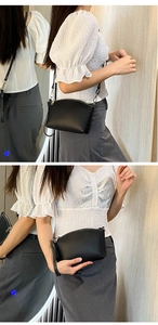 Detail of black crossbody bag with matte texture, silver zipper and detachable strap