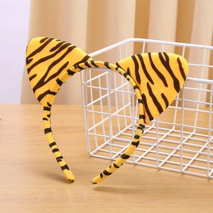 Detailed view of plush tiger print headband with cat ears on a wooden surface
