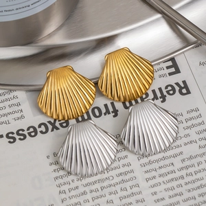 Detailed macro view of 18K gold and silver seashell studs with textured radial stripes