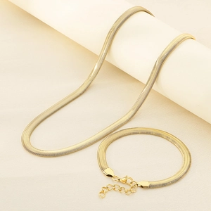 Detail of 18k gold plated flat snake chain set with lobster clasp on a beige background