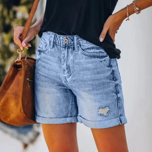 Close-up of light blue distressed denim shorts with fringe hem and ripped details